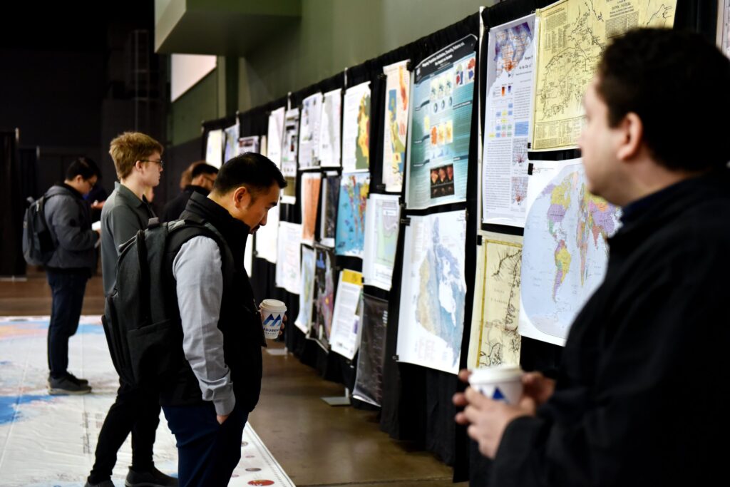 Delegates walk the length of the Canada Maps and Poster Gallery past rows of map entries